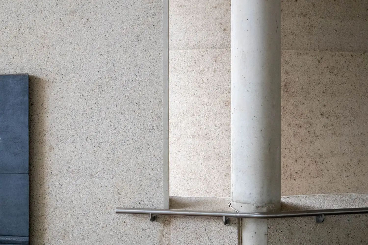 Minimalistische Materialkomposition mit Naturstein und gebogener Wand